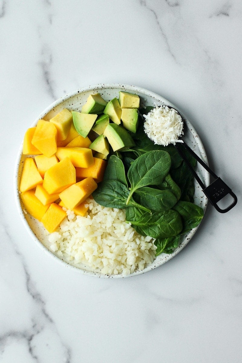 All ingredients for mango avocado energy smoothie bags on a plate