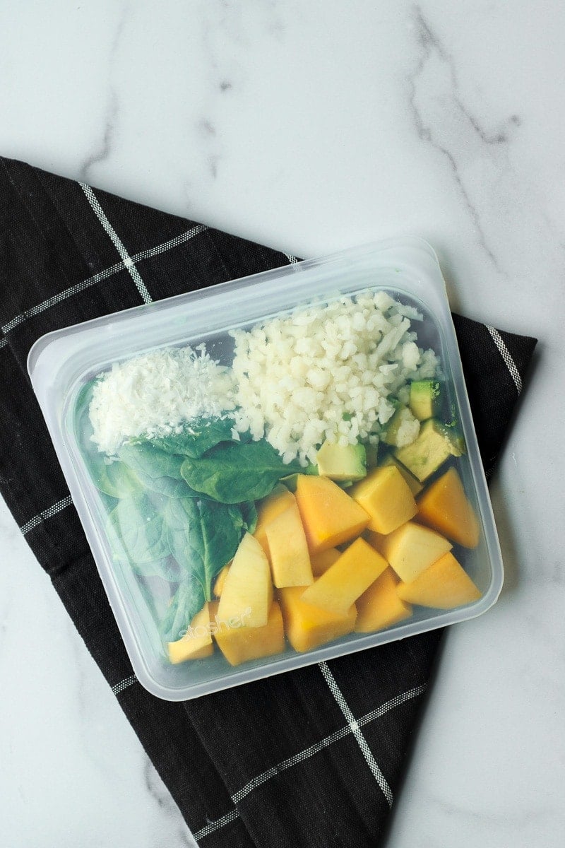 All ingredients for mango avocado smoothie in a reusable freezer bag