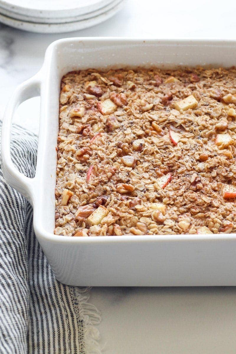 Apple cinnamon baked oatmeal in a baking dish sprinkled with cinnamon