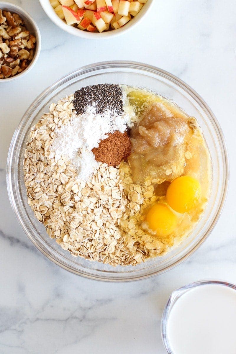 Overhead view of a glass bowl filled with Baked Apple Cinnamon Oatmeal ingredients 