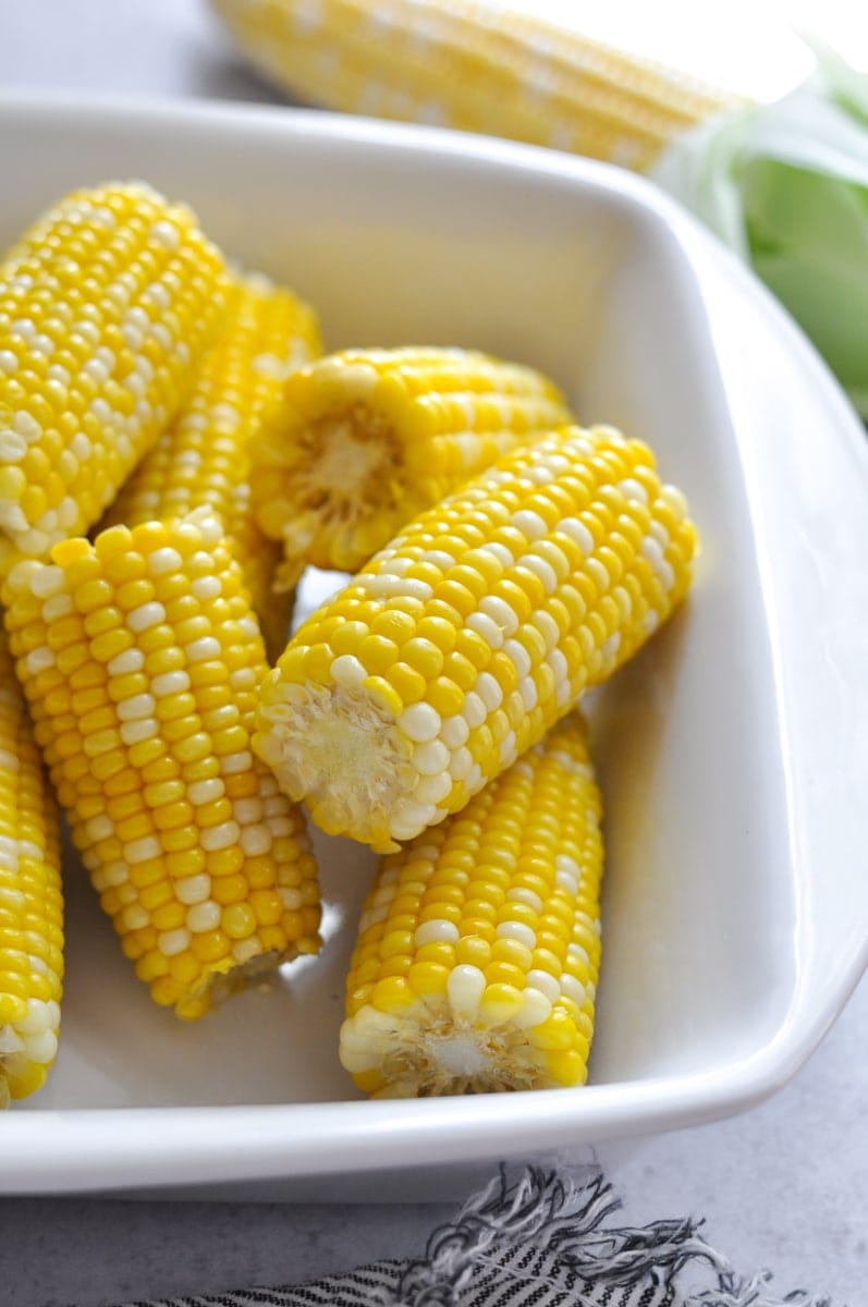 Freshly cooked corn on the corn in a white serving dish