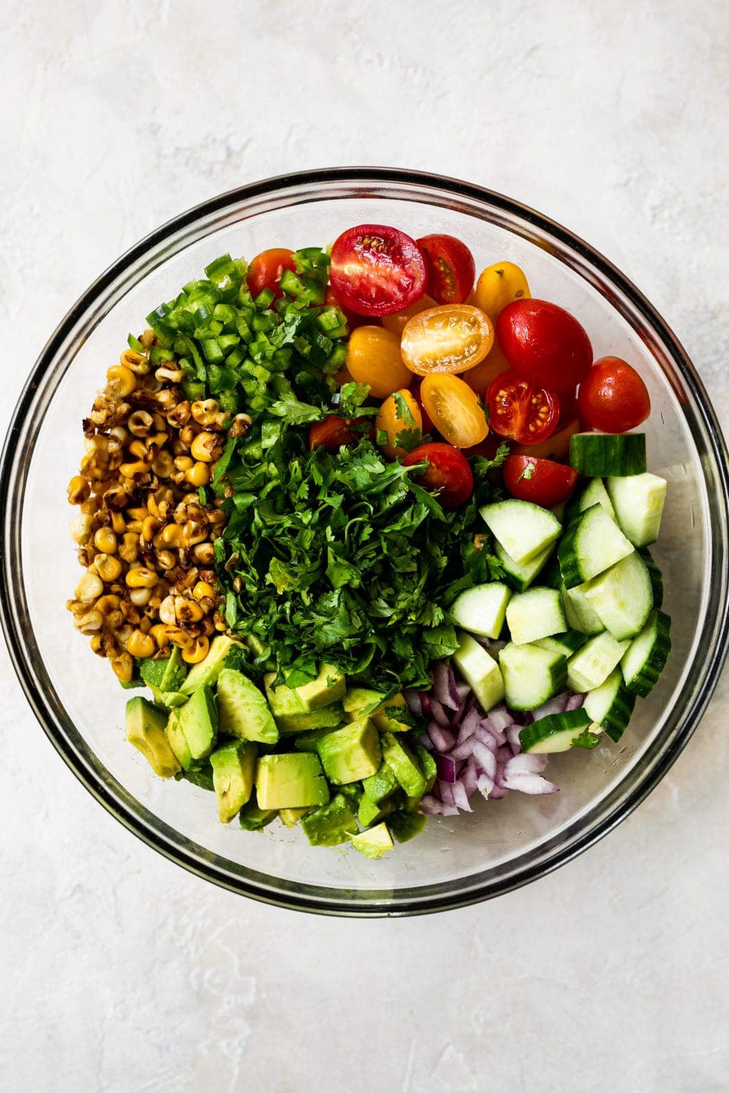 All ingredients for corn salad carefully placed in their own corners of a mixing bowl to show color