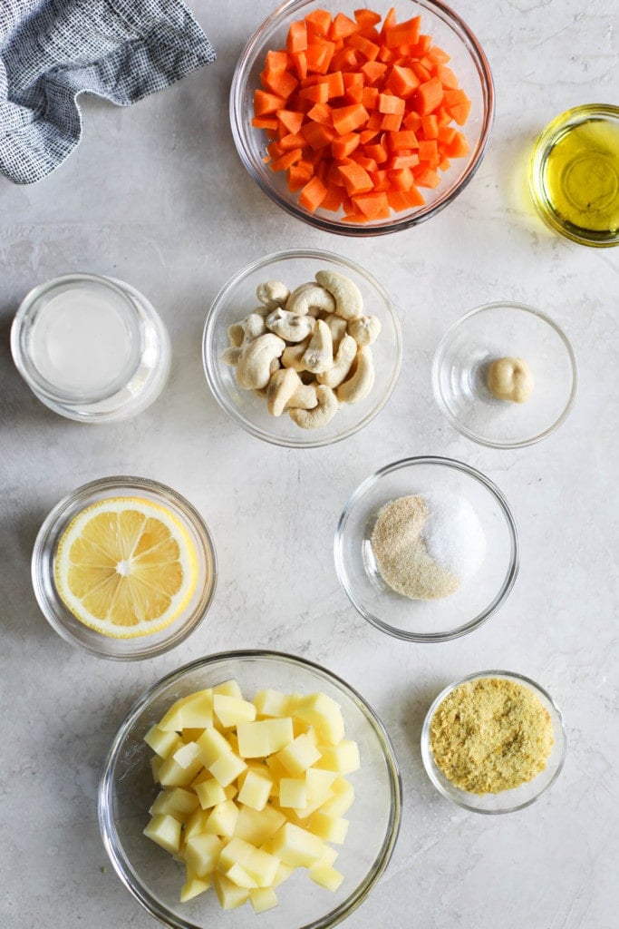 All ingredients for dairy-free cheese sauce in small bowls arranged together.