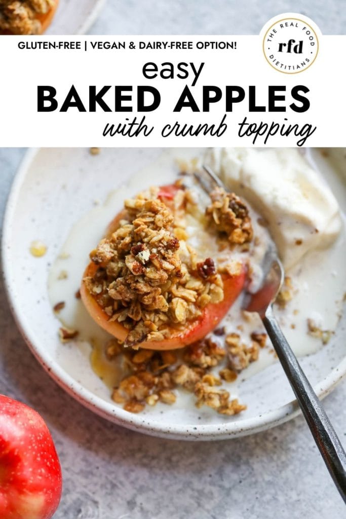 A baked apple half topped with oat and pecan crumble with a scoop of melting ice cream on a plate with a fork cutting into the soft apple.