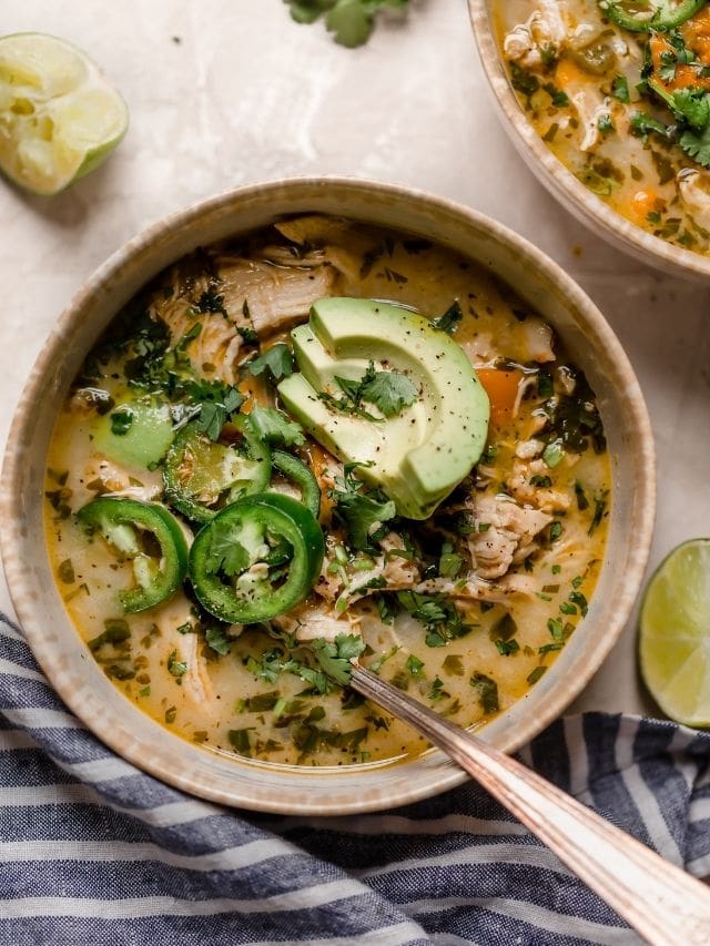 Slow Cooker White Chicken Chili in a bowl topped with jalapeno and avocado slices.