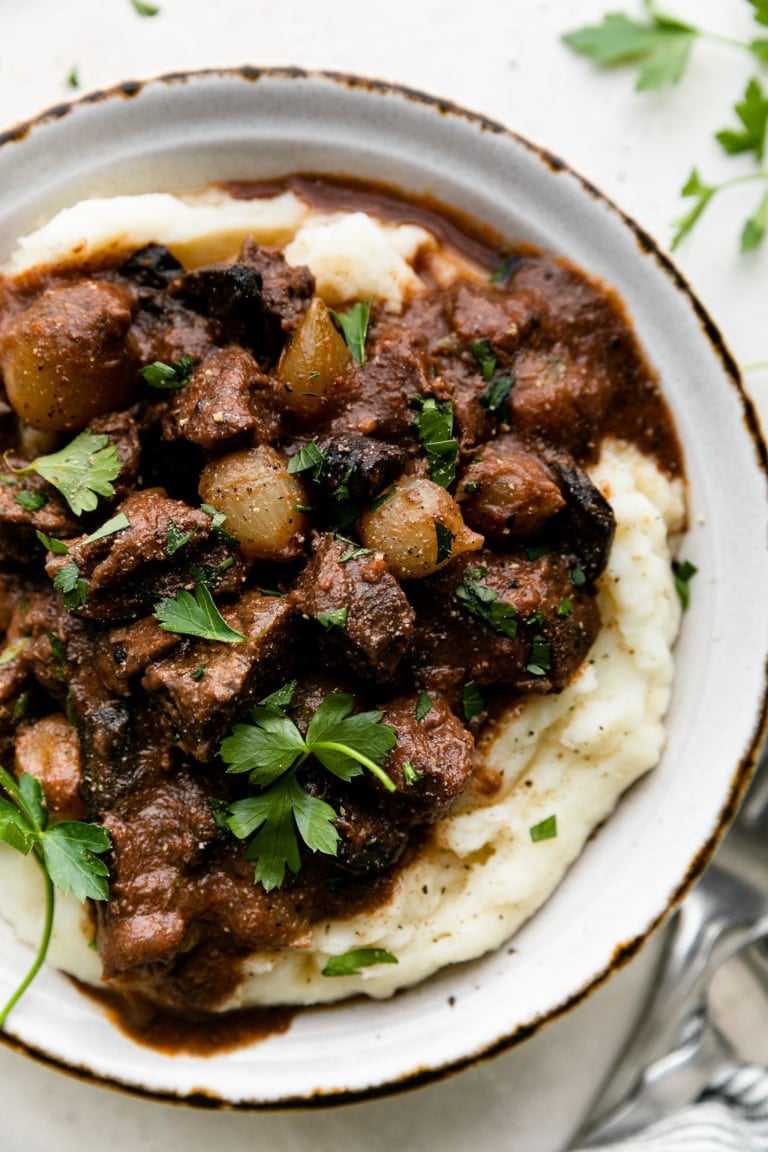 Slow cooker beef tips served over mashed potatoes with gravy