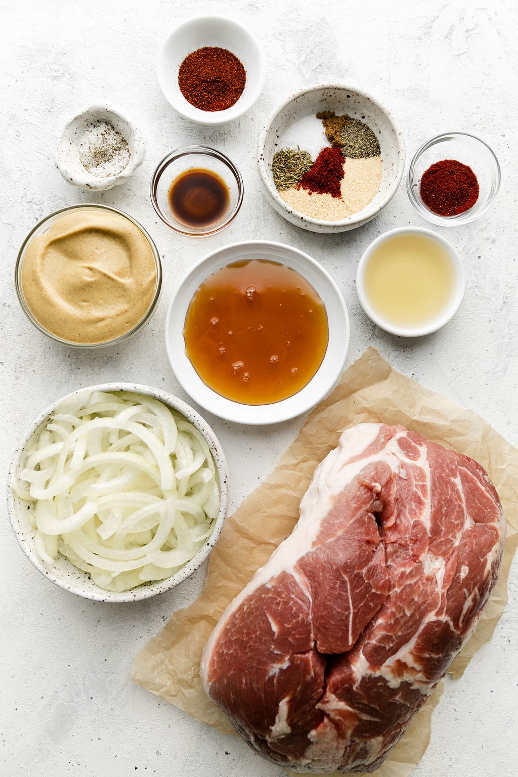 All ingredients for slow cooker pulled pork in small bowls arranged together.