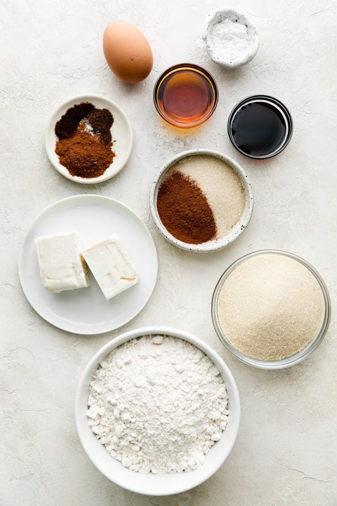 All ingredients for snickerdoodle cookies arranged together in several small bowls.