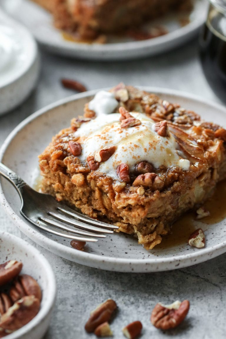 Close up view of a piece of gingerbread baked oatmeal topped with toasted pecans and juicy pears. 