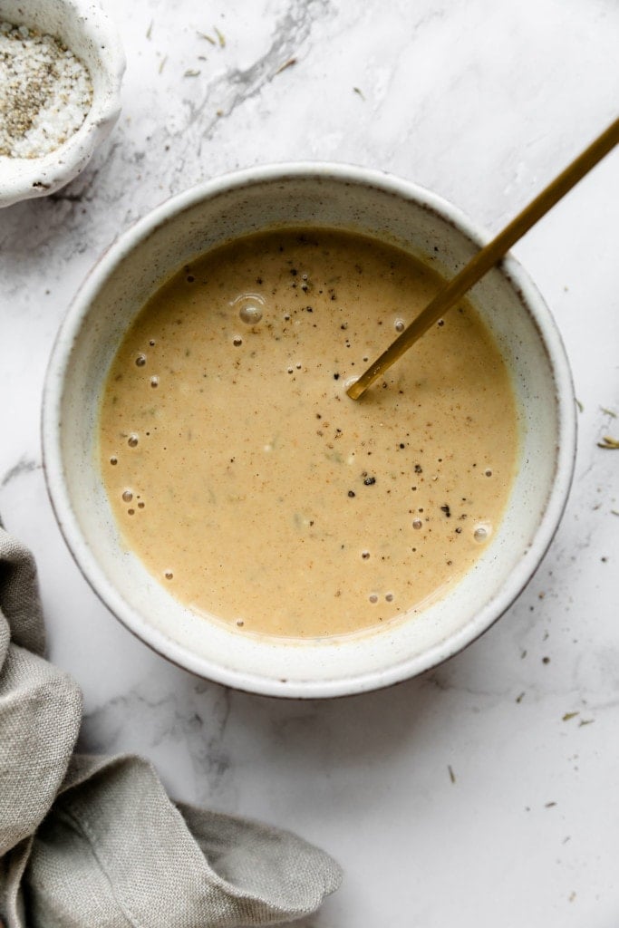 An overhead view of homemade honey mustard sauce in a small stone bowl 