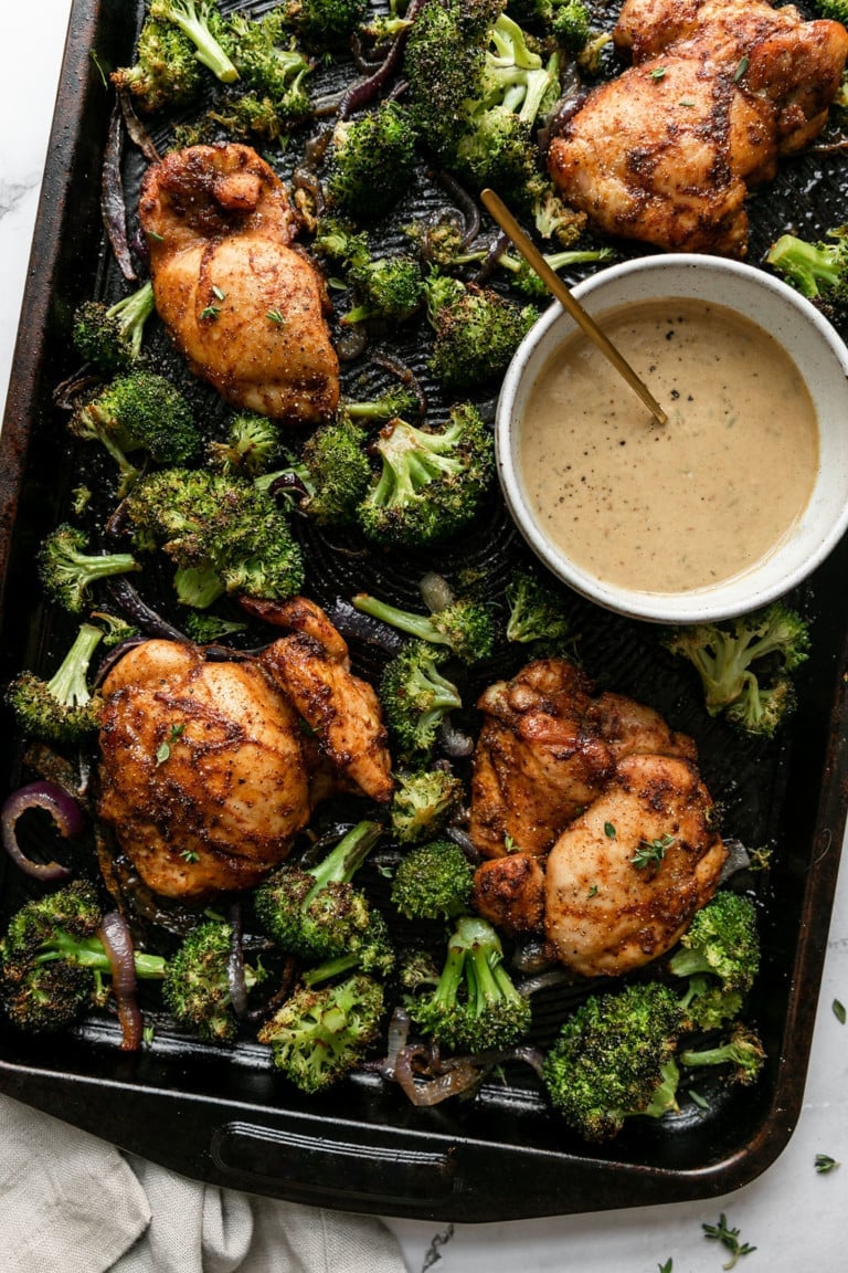 Overhead view sheet pan filled with chipotle chicken thighs and roasted broccoli