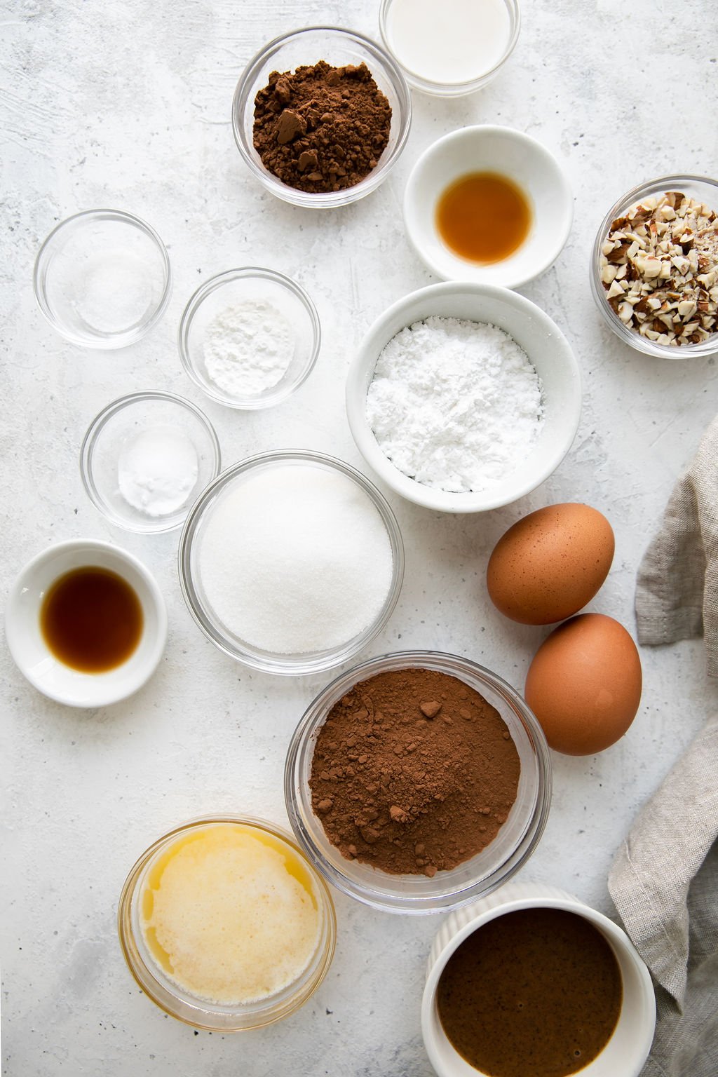 All ingredients for flourless donuts in small bowls arranged together.