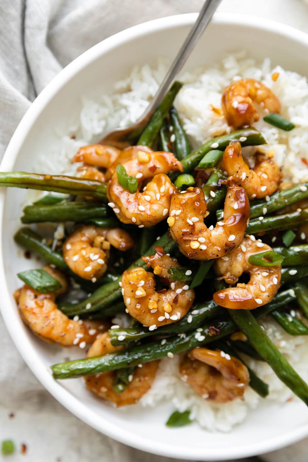 Close up view of a bowl of Sheet Pan Honey Garlic Shrimp over rice.