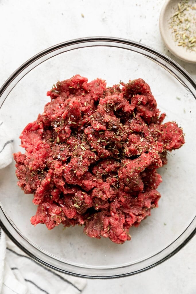Overhead view of a bowl filled with ground beef and seasonings for Easy Grilled Pizza Burgers.