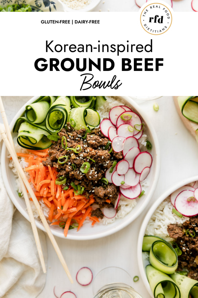 Overhead view Korean-inspired Ground Beef Bowl served over rice in white bowl topped with veggies, chopsticks resting on edge of bowl.