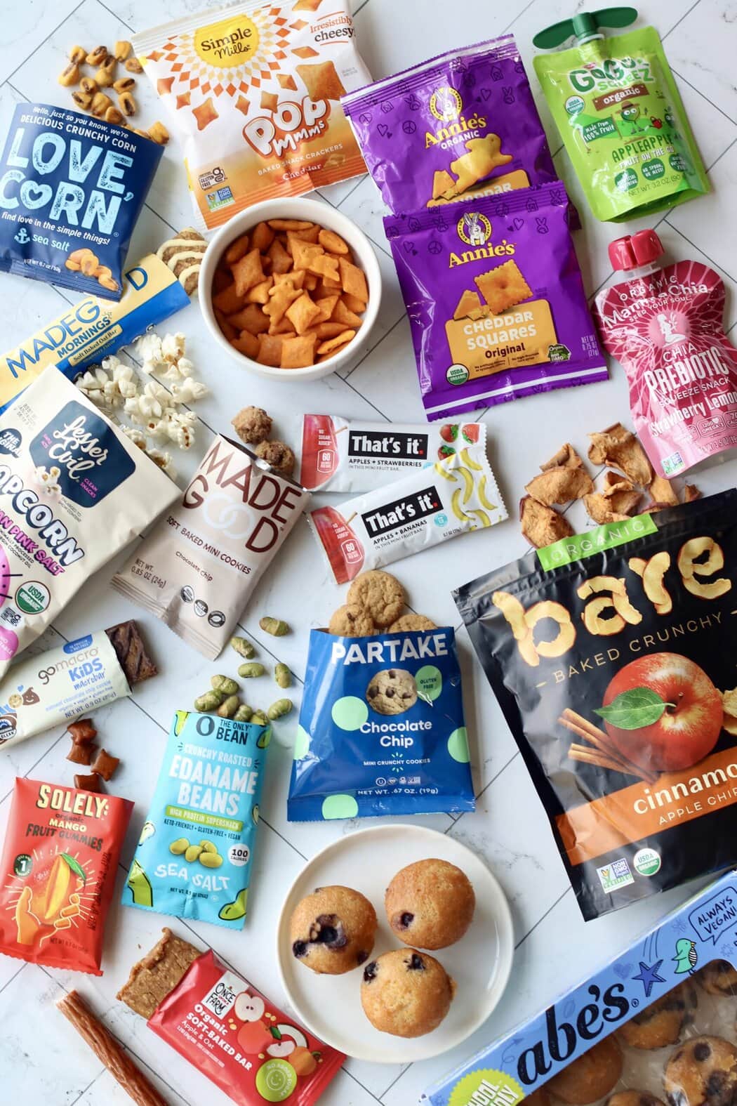 Overhead view of a colorful variety of sweet and savory store bought snacks for kids. 