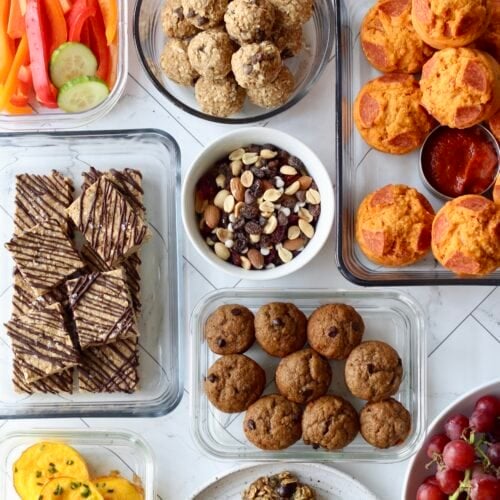 Overhead view several homemade snacks for kids in glass meal prep containers