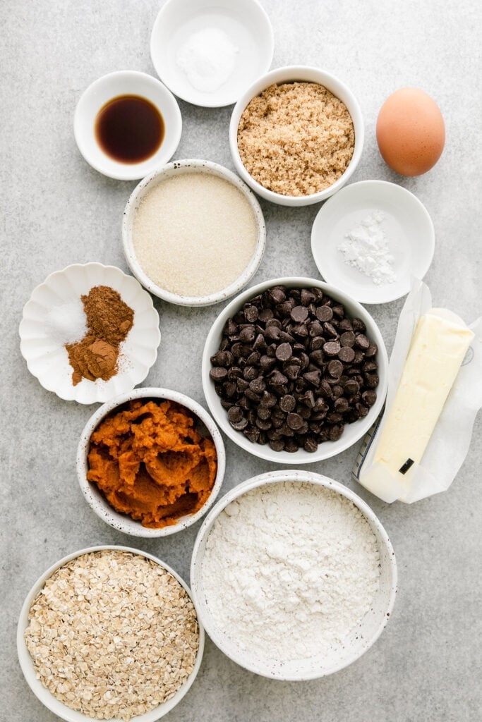 Variety of ingredients for Oatmeal Pumpkin Chocolate Chip Cookies in different sized bowls
