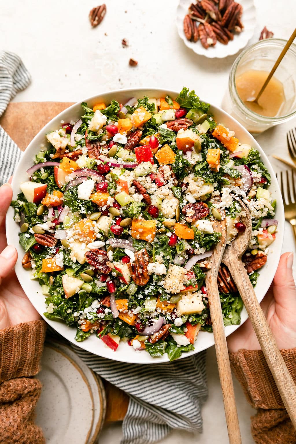 Overhead view white bowl filled with harvest salad with quinoa, butternut squash and pomegranate seeds.