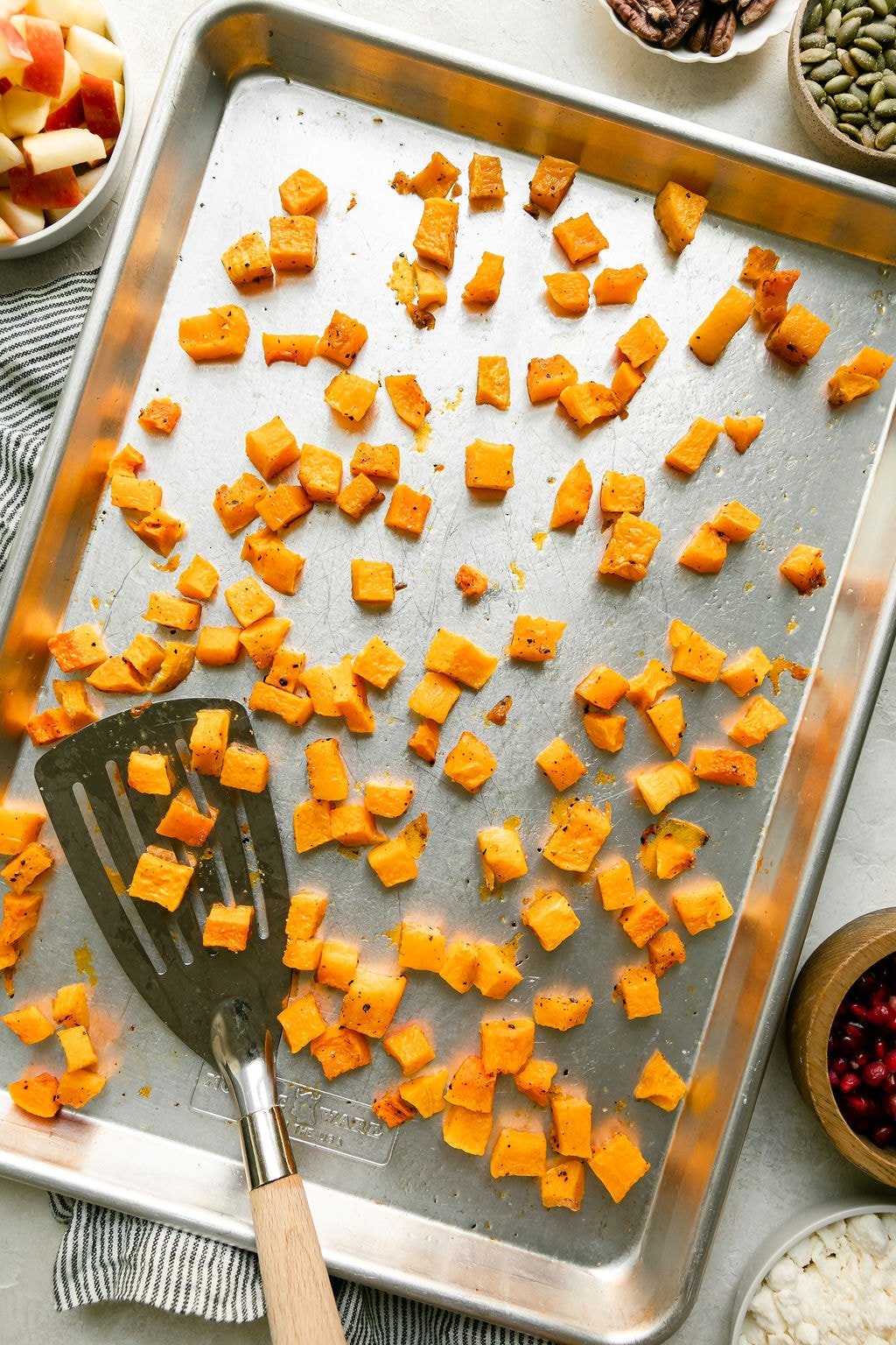 Roasted, diced butternut squash on a metal sheet pan