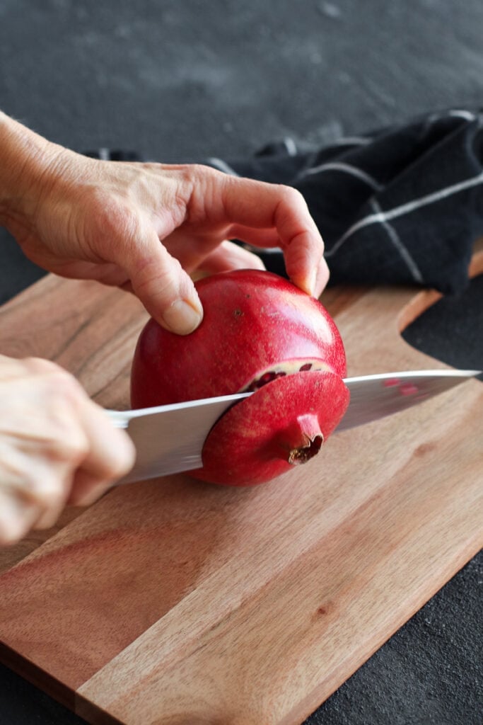 A fresh pomegranate with blossom end being cut off 