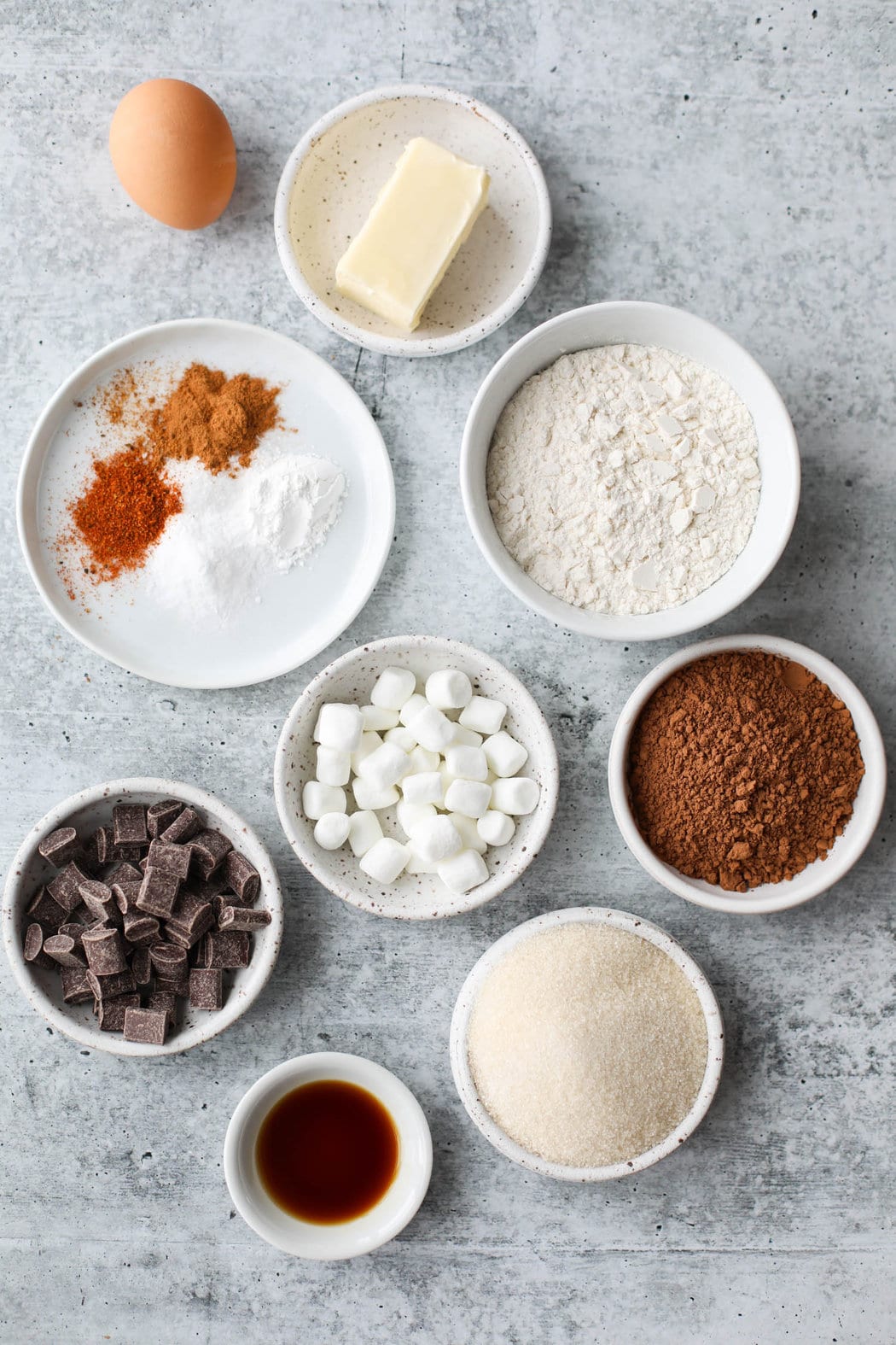 Overhead view all ingredients for Mexican Hot Chocolate Cookies arranged in small bowls.