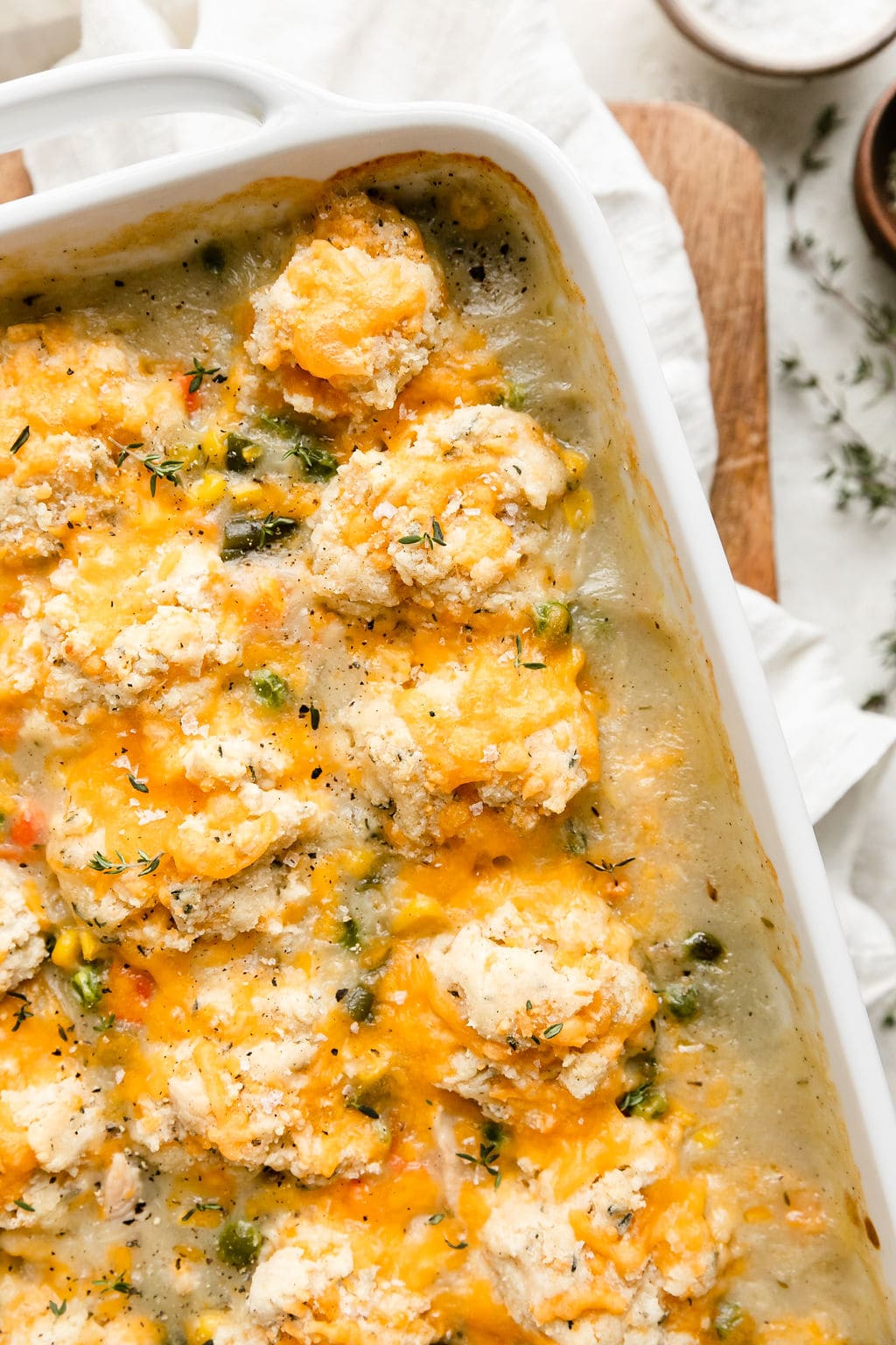 Close up overhead view white casserole dish filled with chicken pot pie topped with drop biscuits.