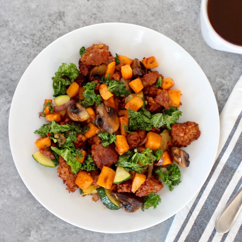 Overhead view of a plate of a breakfast hash with colorful vegetables. 