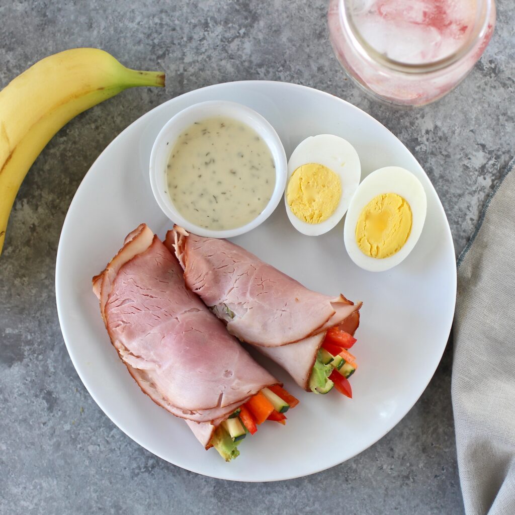 A plate of Veggie Avocado Deli Meat Wraps + Fruit