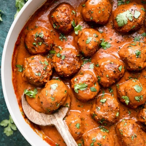 Overhead view skillet filled with beef and lentil meatballs in sauce.