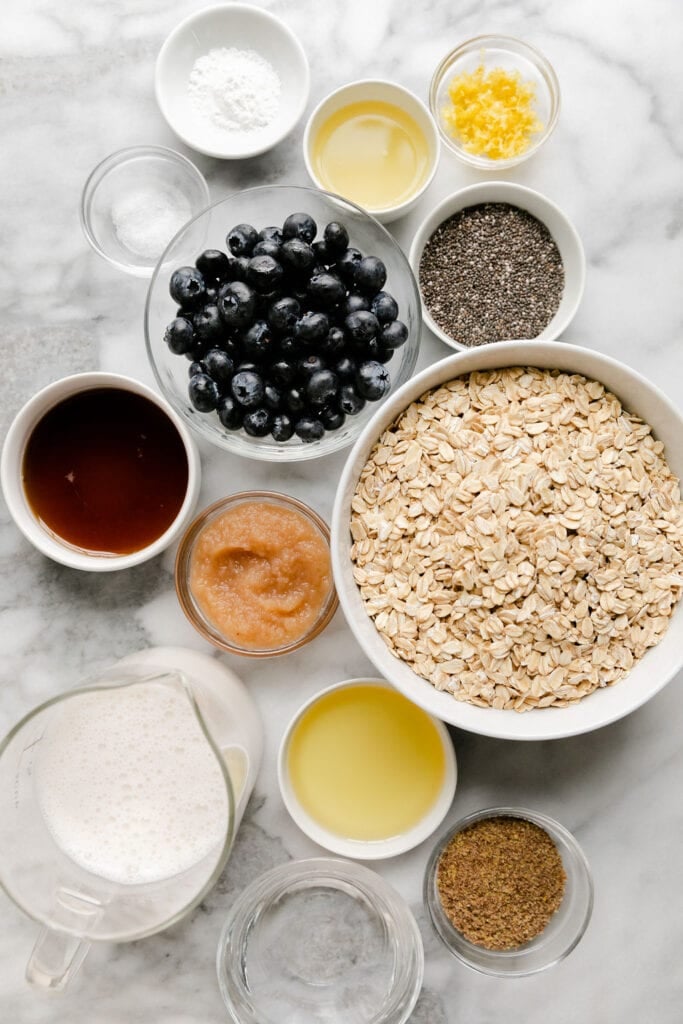 All ingredients for blueberry lemon baked oatmeal in small bowls.
