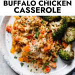 Serving of creamy buffalo chicken casserole on stone plate with roasted broccoli on side