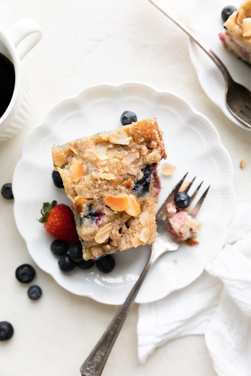 A slice of mixed berry breakfast cake on white plate