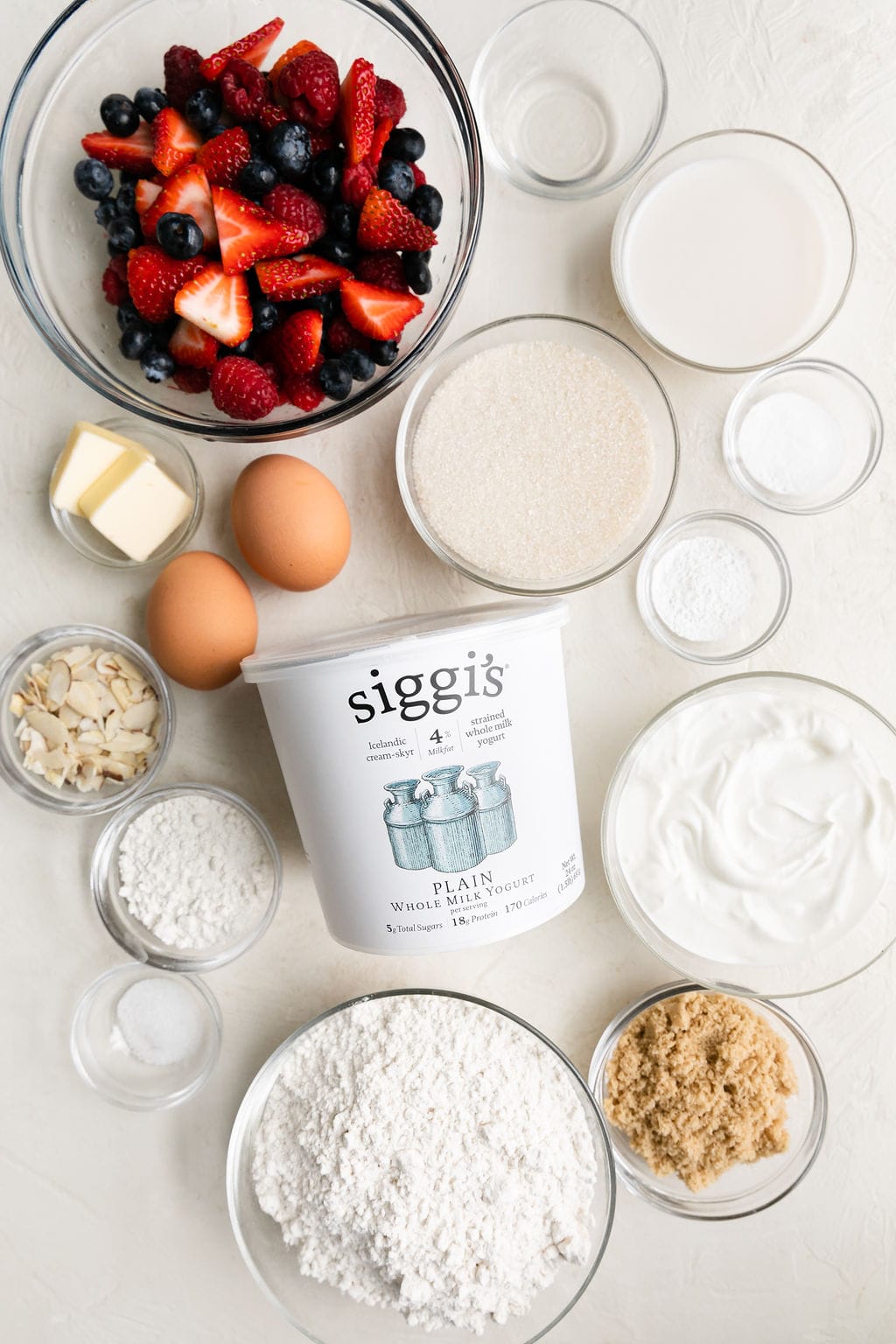 All ingredients for mixed berry breakfast cake arranged in small bowls.