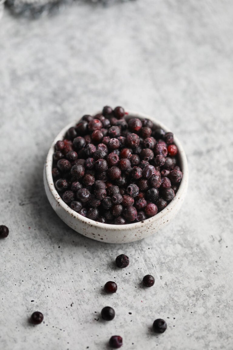 Overhead view of a bowl of frozen wild blueberries. 