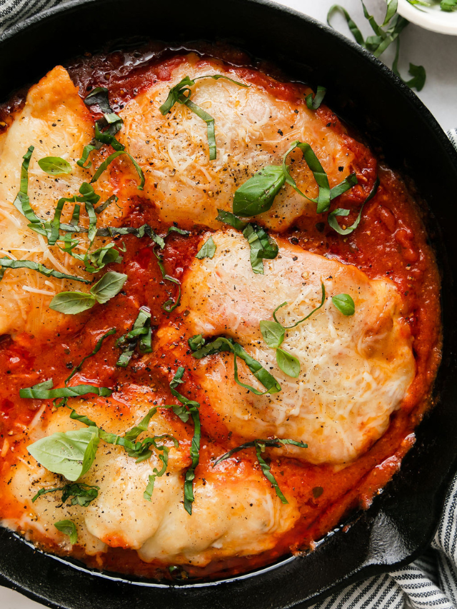 Chicken parmesan in marinara sauce in cast iron skillet.