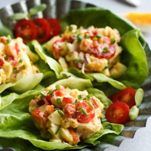 Three large lettuce leaves filled with BLT egg salad.