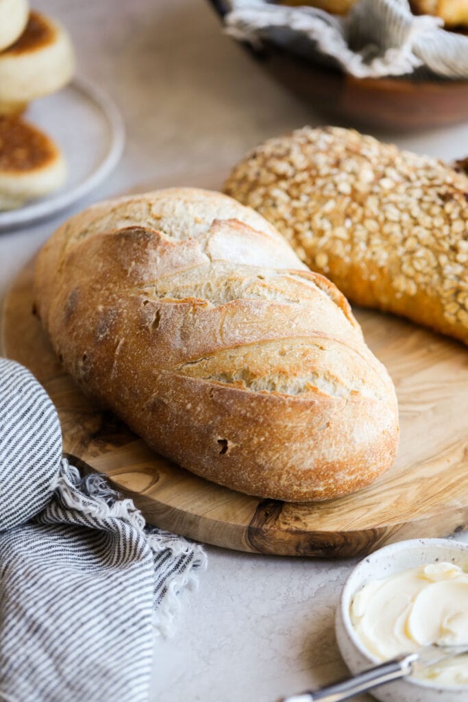 Close up view of freshly baked sourdough bread on a wood cutting board.