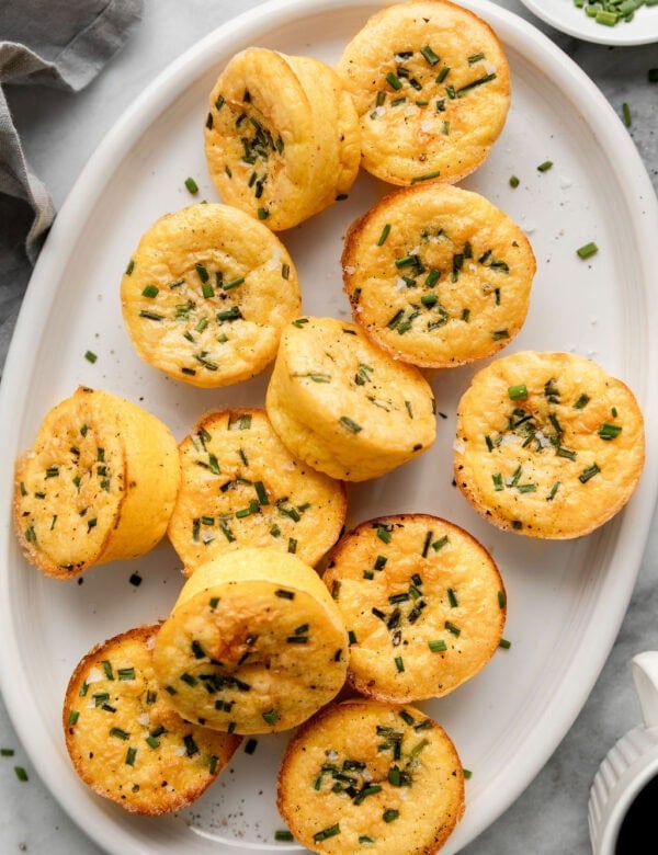 Cottage cheese egg bites topped with chives on white serving platter