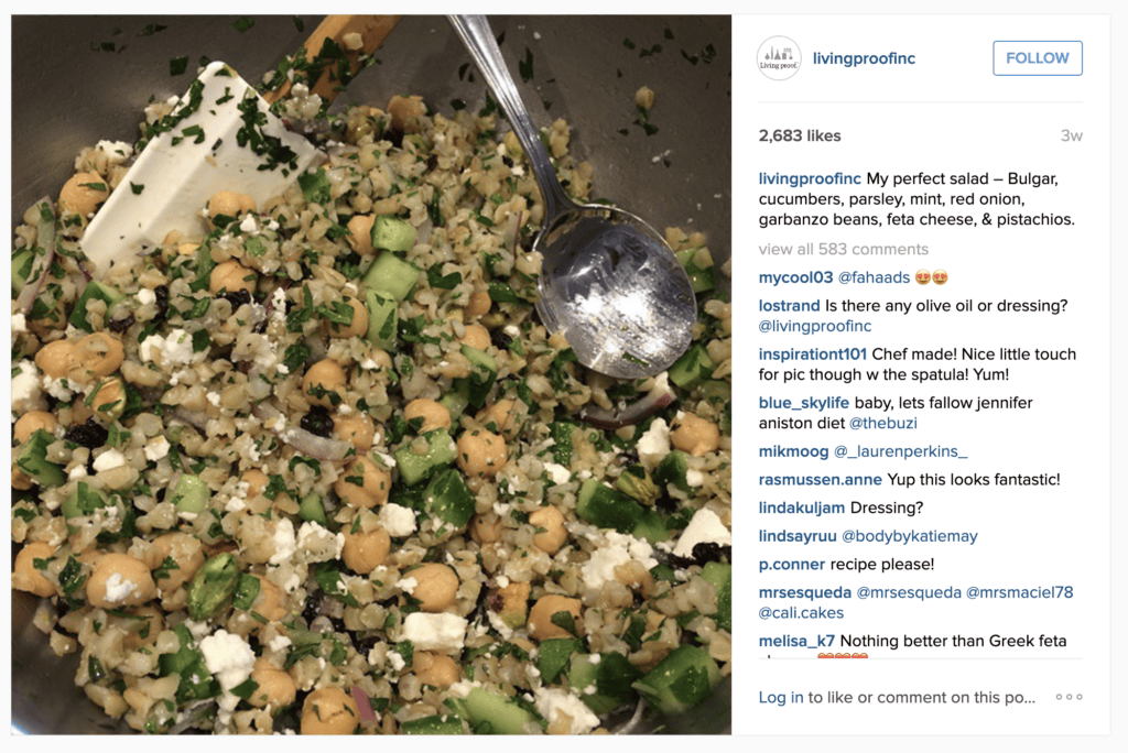 A bowl of jennifer aniston salad being stirred with a metal spoon. 