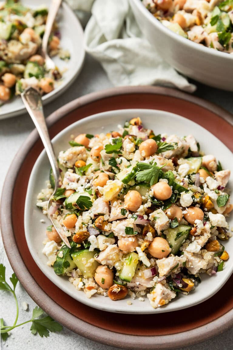 Close up view of a plate of Jennifer Aniston salad topped with fresh herbs and crumbles of feta cheese.