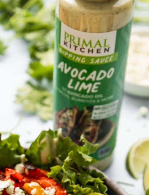 Grilled Chicken Fajita Salad with a bottle of avocado lime sauce beside it.