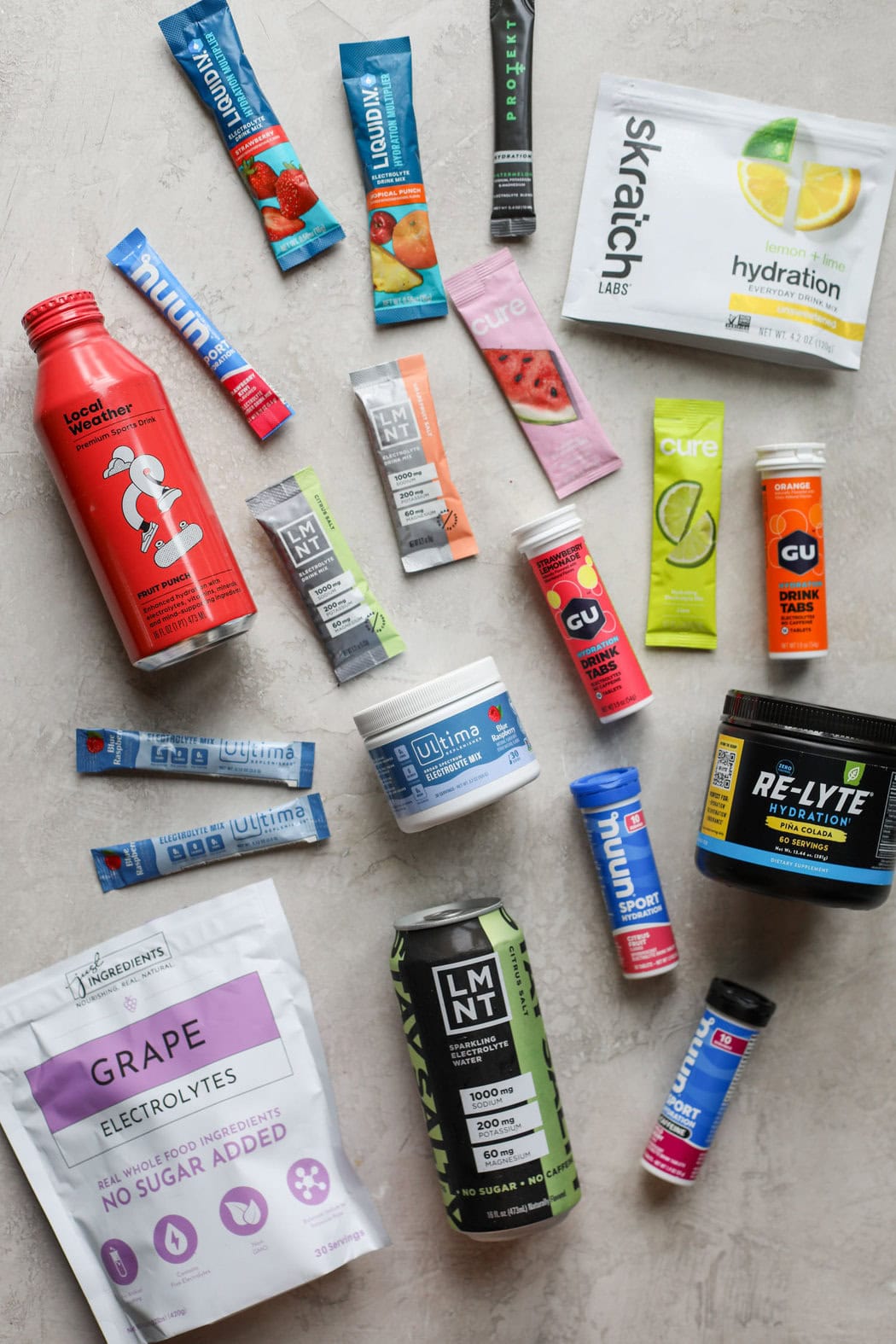 A colorful variety of different electrolyte supplements and drinks on a marble background. 