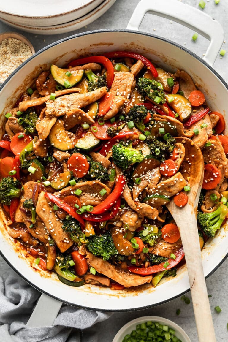Overhead view of a skillet filled with Healthy, One-Pan Orange Pork Stir-Fry topped with sesame seeds