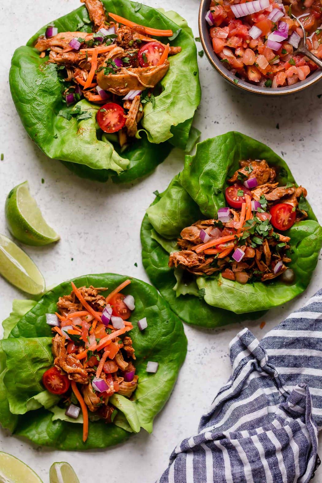 Overhead view of Chicken Tacos on lettuce wraps topped with chopped onions and sliced carrots