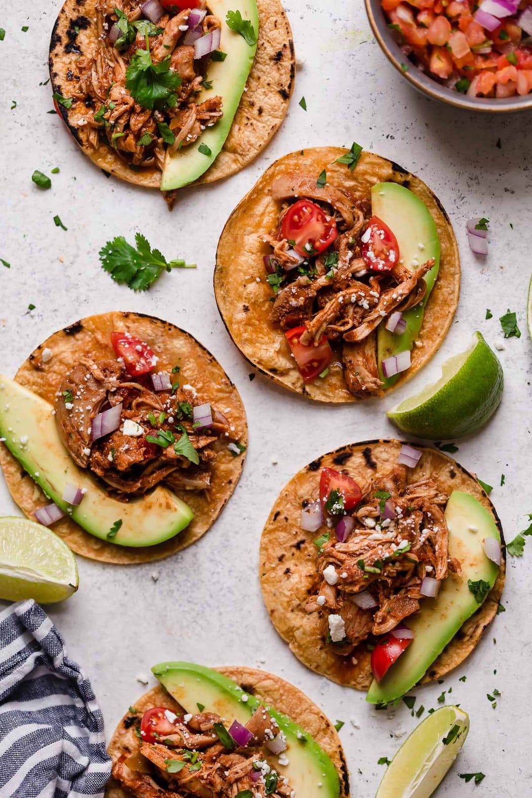 Overhead view of Chicken Tacos topped with avocado slices and fresh cilantro.