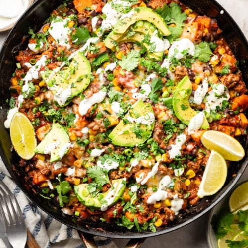overhead view ground beef zucchini skillet in cast iron skillet topped with sour cream