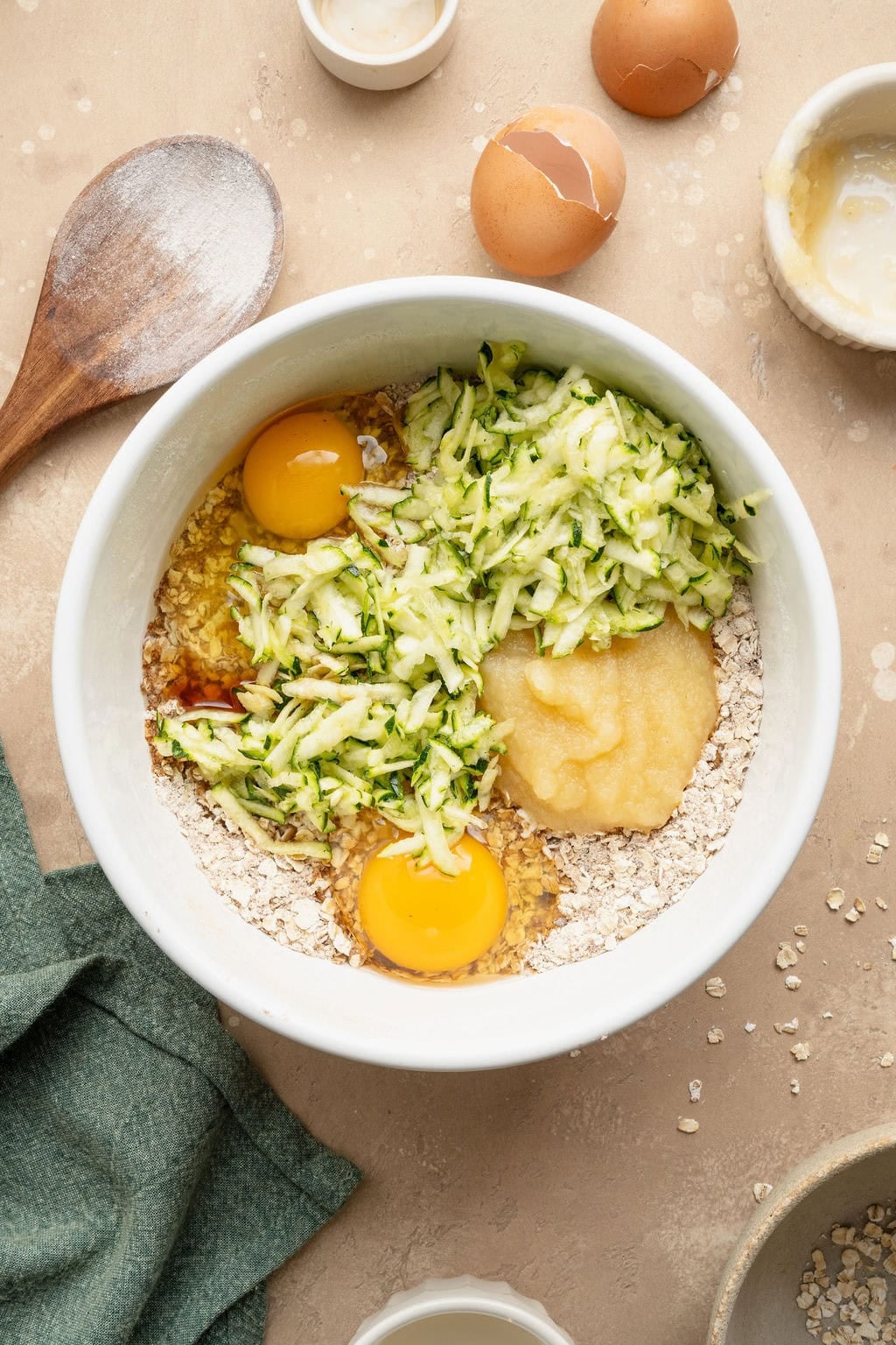 Wet ingredients on top of dry ingredients in a bowl to make zucchini breakfast cookies.