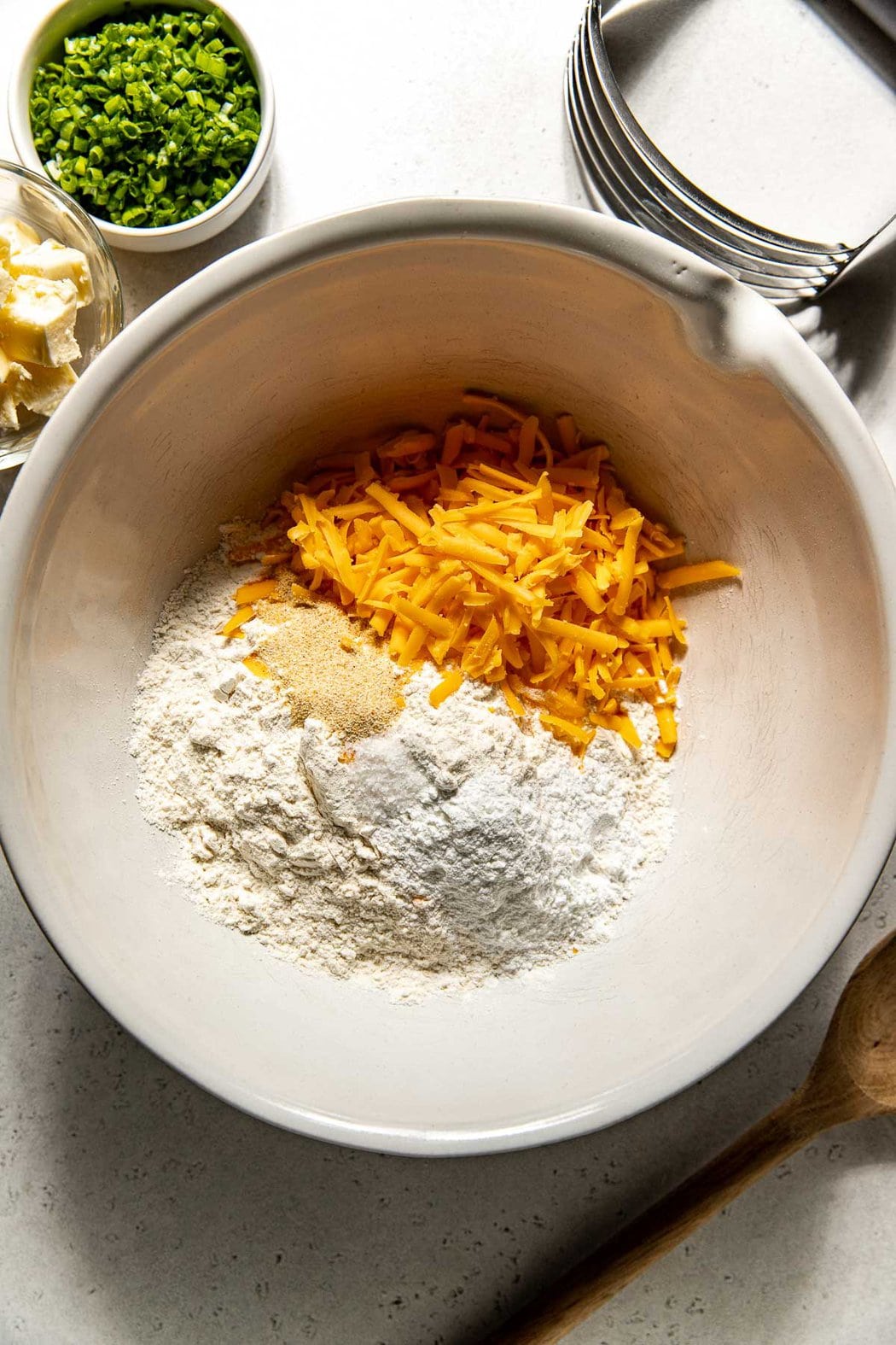 Overhead view of a bowl of biscuit ingredients ready for mixing. 