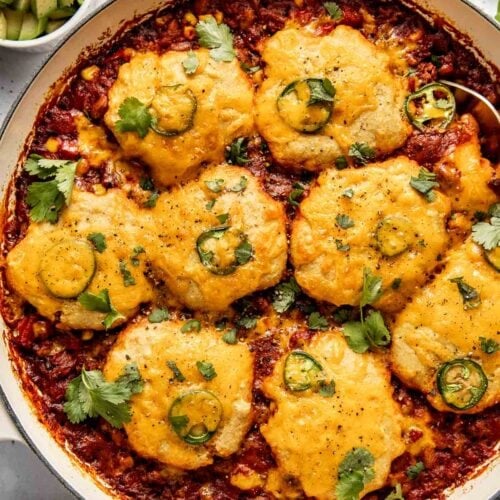 Chili Cornbread Casserole in a skillet topped with jalapenos and melted cheese